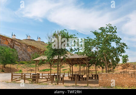 Tische und Bänke auf dem Hintergrund der Windmühlen in der Stadt von Consuegra Spanien Stockfoto