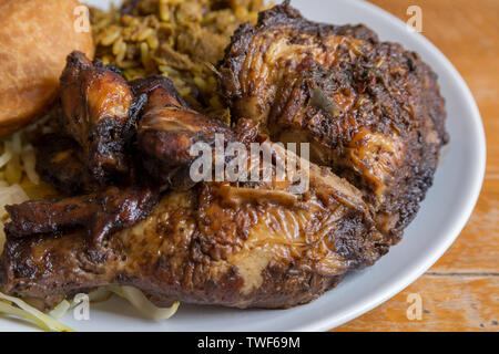 Die jamaikanische Essen. Traditionellen jamaikanischen Ziege, Jerk Chicken Curry und gebratene Knödel mit Reis und Erbsen. Stockfoto