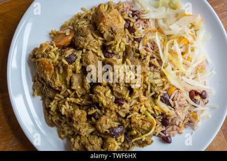 Die jamaikanische Essen. Jamaican Curry Goat serviert mit Reis und Erbsen Stockfoto