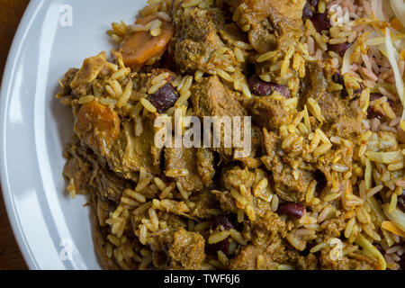 Die jamaikanische Essen. Jamaican Curry Goat serviert mit Reis und Erbsen Stockfoto