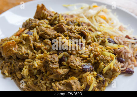 Die jamaikanische Essen. Jamaican Curry Goat serviert mit Reis und Erbsen Stockfoto