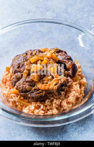 Osso Buco, Kalbfleisch Schäfte, die in Wein mit Safran Risotto geschmort, gebraten roten Pfeffer und Rosmarin. Organische traditionelles Essen. Stockfoto