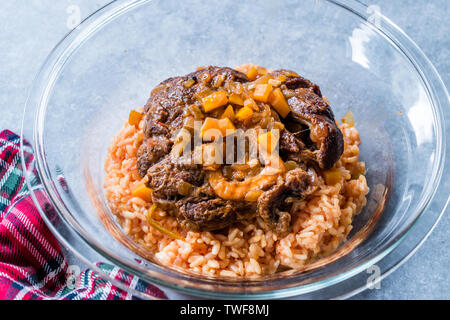 Osso Buco, Kalbfleisch Schäfte, die in Wein mit Safran Risotto geschmort, gebraten roten Pfeffer und Rosmarin. Organische traditionelles Essen. Stockfoto