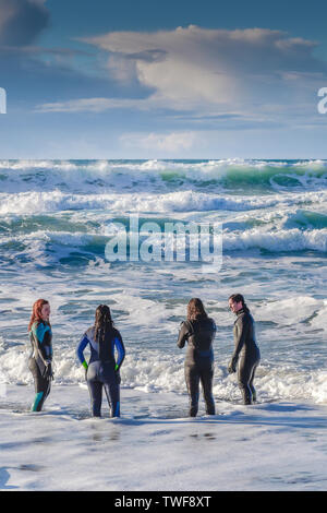 Menschen in Neoprenanzüge im Meer bei Fistral Beach in Newquay in Cornwall. Stockfoto