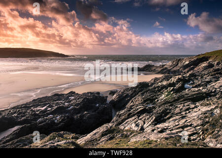 Ein spektakulärer Sonnenuntergang über Crantock Strand bei Ebbe in Newquay in Cornwall. Stockfoto