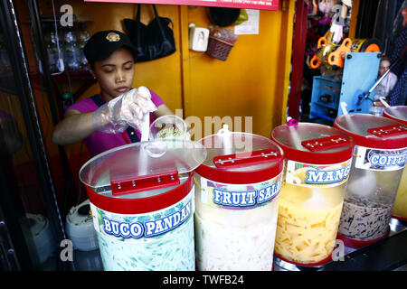 ANTIPOLO CITY, Philippinen - 18. JUNI 2019: eine Frau verkauft verschiedene Fruchtsäfte und andere Erfrischungen an einem heißen Sommertag. Stockfoto