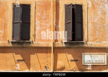 Öffnen Fensterläden in einer verwitterten Wand. Stockfoto