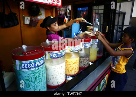 ANTIPOLO CITY, Philippinen - 18. JUNI 2019: eine Frau verkauft verschiedene Fruchtsäfte und andere Erfrischungen an einem heißen Sommertag. Stockfoto