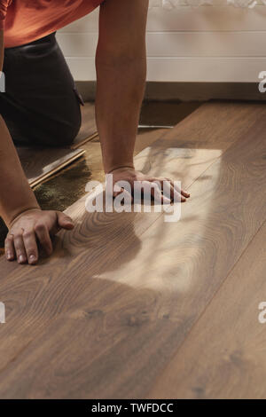 Hände der Arbeiter Drücken der Planken bei der Verlegung Laminat Stockfoto