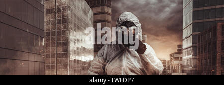 Überlebende mit weißer Schutz insgesamt und Gasmaske Holding eine kleine Kugel vor den Gebäuden Stockfoto