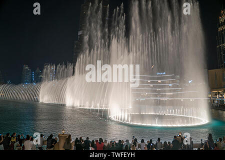 Menschenmassen heben ihre Telefone die beeindruckenden Springbrunnen Show in Dubai zu erfassen. Stockfoto