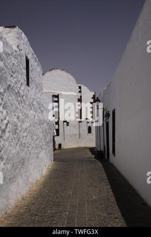 TEGUISE, LANZAROTE - juin 2013 3. 2019: Blick in leere Gasse mit weissen Häusern gegen den blauen Himmel Stockfoto