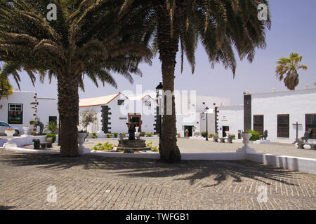 TEGUISE, LANZAROTE - juin 2013 3. 2019: Blick über Platz mit Palmen, bei der die traditionellen weißen Häuser Stockfoto