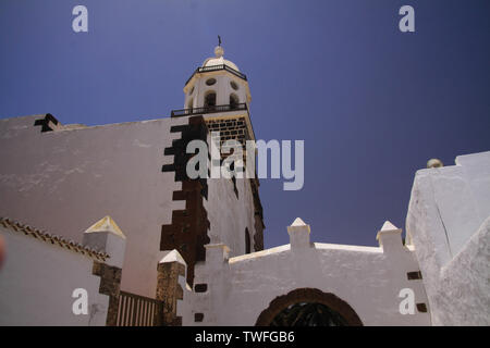 TEGUISE, LANZAROTE - juin 2013 3. 2019: Blick auf weiße Kirche mit Glockenturm gegen den blauen Himmel Stockfoto