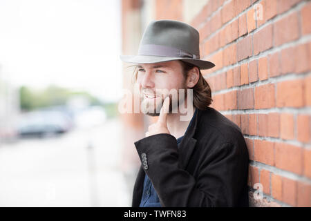 Porträt eines Mannes gegen eine Wand an seinem Gesicht zeigen Schiefe Stockfoto