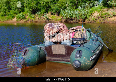 Der Fischer schläft in einem Schlauchboot an der Küste Fluss Stockfoto