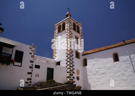 BETANCURIA, Fuerteventura - JUIN 14. 2019: Blick auf die weißen Wände und Uhrturm gegen den blauen Himmel Stockfoto