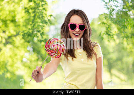 Jugendmädchen in Sonnenbrille mit Lollipop Stockfoto