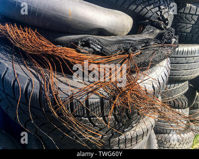 Das Bild des alten abgenutzten Reifen. Der Gummi ist umgekommen, und die Drähte des Körpers sind und rostig. Zeigt den Aufbau des Reifens. Stockfoto