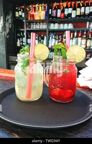 Im Sommer Kühlung cocktails Mojito und Erdbeere frisch in ein Glas Marmeladenglas auf einer Theke Stockfoto