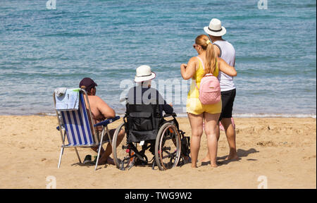 Ältere Frau im Rollstuhl am Strand. Stockfoto