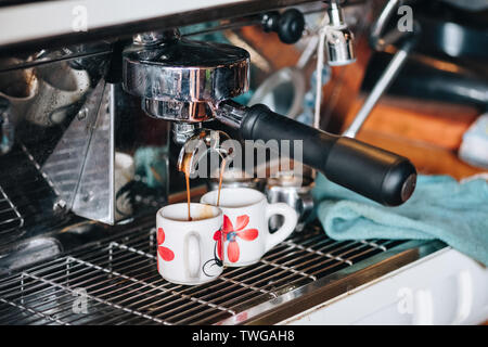 Kaffeemaschine Kaffee fließt in zwei Cup Stockfoto