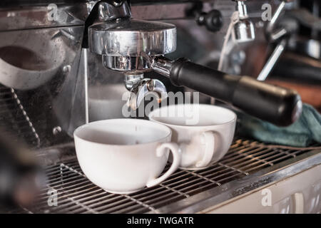 Kaffeemaschine Kaffee fließt in zwei Cup Stockfoto