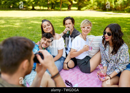 Freunde mit Getränken fotografieren im Sommer Picknick Stockfoto