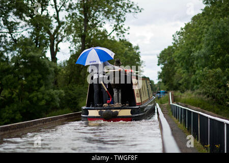 Urlauber Schutz vor Regen auf einem 15-04 Die edstone Aquädukt Kreuz während einer warmen und angenehmen Tag in Warwickshire, Großbritannien. 20. Juni 2019. Stockfoto