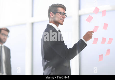 Mitarbeiter liest klebrig - Hinweise auf Glas. Stockfoto