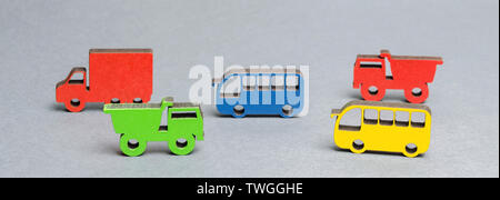 Miniatur Spielzeug Holz- Fahrzeuge auf einem grauen Hintergrund. Das Konzept der Stadt verkehr laden. Die Einführung des öffentlichen Verkehrs. Einschränkung der Person Stockfoto