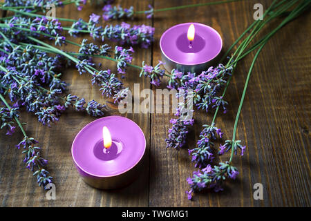Spa Massage Einstellung mit Lavendelblüten, Duftkerzen auf Holz- Hintergrund. Stockfoto