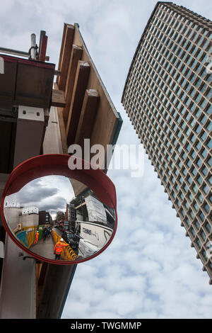 Die Bauarbeiter in Konvexe Spiegel an der Tottenham Court Road crossrail gesehen arbeitet neben dem Centrepoint Tower London, Stockfoto