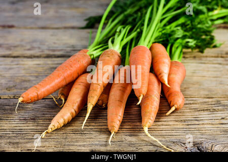 Bündel von Frische und süße Karotte auf einem alten Holztisch. Stockfoto