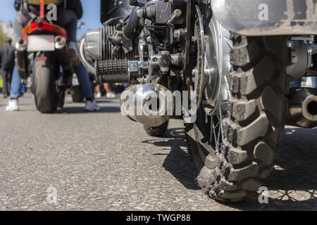 Das Hinterrad des Motorrades und Auspuffrohr, Asphalt und Stau im Hintergrund Stockfoto