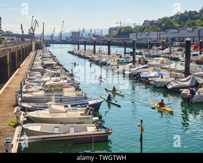 Kinder Kajakfahren in der Muelle del Hospitalillo Hafen von Trintxerpe, an einem sonnigen Tag. Pasaia, Gipuzkoa, Baskenland, Spanien. Stockfoto