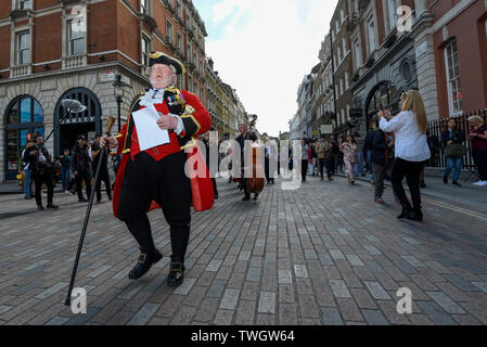 London, Großbritannien. 20. Juni 2019. Alan Myatt, stadtausrufer, und einer Blaskapelle nehmen Sie Teil an den historischen "Mieten Zeremonie" in Covent Garden. Eine Parade des Kuratoriums der Covent Garden Area Vertrauen begleitet von der Oberbürgermeister von Westminster, stellvertretender Bürgermeister von Camden und andere dignatories sowie Straßenkünstler März rund um die Piazza, wo das Kuratorium einen symbolischen "Pfeffer Miete zahlen", bestehend aus fünf Rosige rote Äpfel und fünf posies von Blumen und posies sind als Miete an den Vermieter gezahlt. Credit: Stephen Chung/Alamy leben Nachrichten Stockfoto