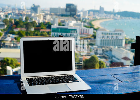 Laptop auf Holztisch mit modernen Blick auf die Stadt Stockfoto