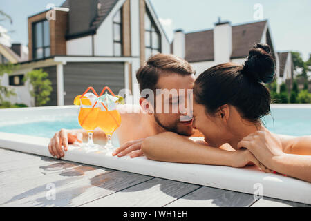 Happy heterosexuellen Paaren ist gut mit Cocktails, während im Pool ausgeruht. Sommer rest