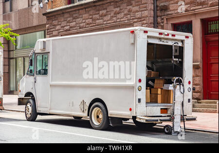 Von Tür zu Tür Lieferung. Pakete in eine weiße Farbe, Lkw mit offener Tür, auf einer Straße in der Innenstadt, New York geparkt Stockfoto