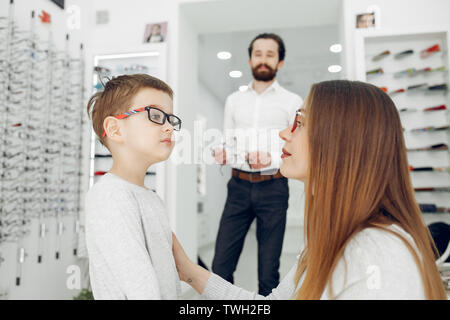 Mutter mit kleinen Sohn in die Gläser store Stockfoto