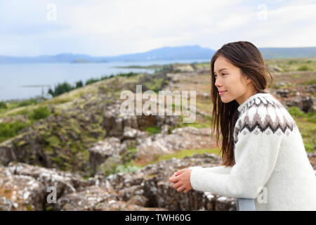 Island - die Frau, die in der isländischen Pullover bei Thingvellir Ort der Althing, das erste Parlament der Welt. Mädchen an Touristen Destination Sightseeing. Stockfoto