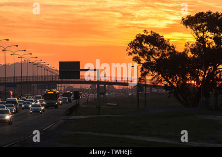 Ein Blick auf den Datenverkehr auf einer Bundesstraße in der Stadt Kapstadt, Südafrika in der Abenddämmerung. Stockfoto