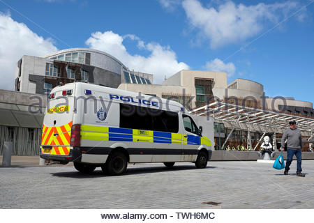 Edinburgh, Vereinigtes Königreich. Juni, 2019 20. Polizeipräsenz an Aussterben Rebellion symbolische Tanz der Toten und Sterben, vom Aussterben Rebellion Schottland auf dem Gelände des Holyrood Park außerhalb des Schottischen Parlaments gehostet werden, dies ist die Reduzierung des CO2-Ausstoßes führen zu markieren, und der Druck auf die Politiker, die das Klima Bill auf dem 18. und 25. Juni Debatte zu halten. Quelle: Craig Brown Stockfoto