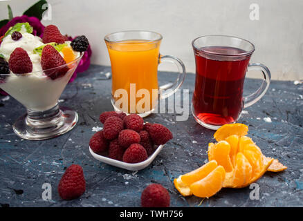 Mandarinensaft und Himbeere, in Tassen, Eis mit Beeren. Stockfoto