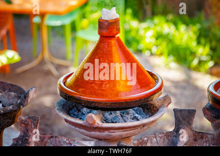 Das Kochen der traditionellen Marokkanischen tajin Gerichte. Dies ist Fleisch und einige vegatebles oder Früchte. Dieses typische Essen ist in afrikanischen Keramik Behälter gekocht. Stockfoto
