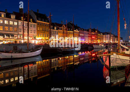 Kopenhagen, Dänemark: 18. April 2019: Beleuchtete Häuser und Schiffe an Nyhavn in der Nacht, einen alten Kanal und Unterhaltung Zone in Kopenhagen Stockfoto