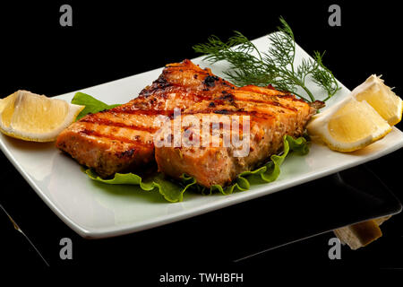 Fisch, Forelle, chum salmon, Buckelwale, ein Stück gebacken, gegrillt, mit einer Scheibe Zitrone und Salat Stockfoto