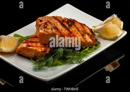 Fisch, Forelle, chum salmon, Buckelwale, ein Stück gebacken, gegrillt, mit einer Scheibe Zitrone und Salat Stockfoto