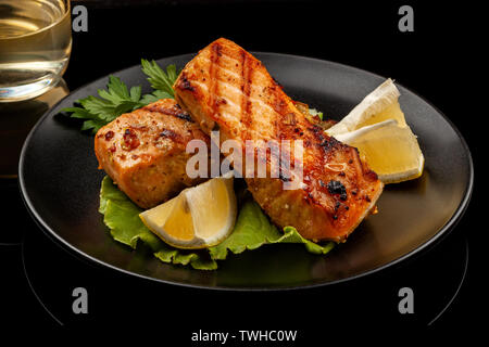 Fisch, Forelle, chum salmon, Buckelwale, ein Stück gebacken, gegrillt, mit einer Scheibe Zitrone und Salat Stockfoto